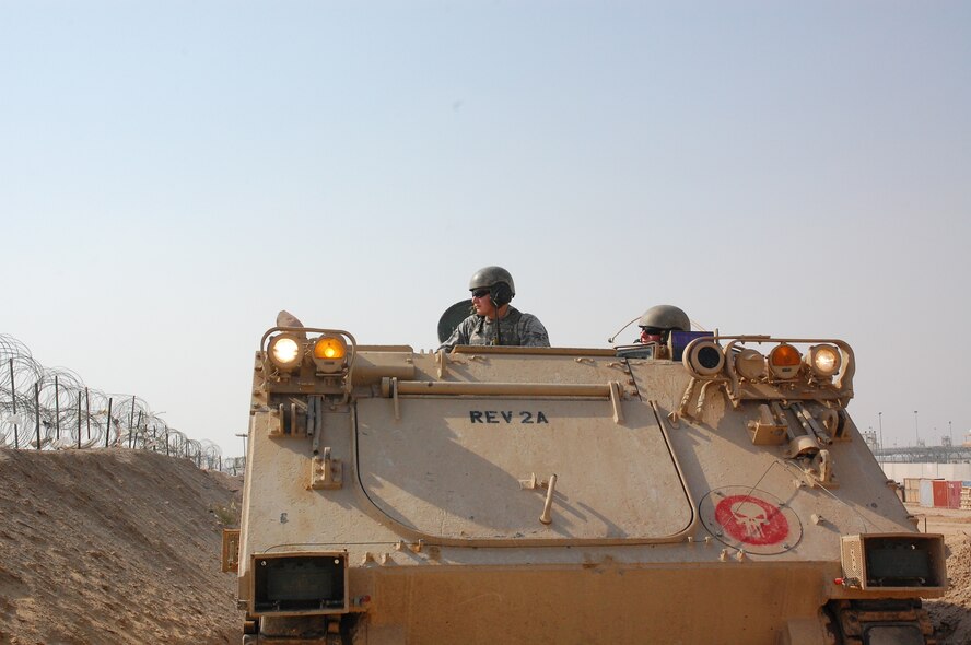 CAMP BUCCA, Iraq – Senior Airman Travis Hummel, left, and Airman 1st Class Adam Giebitz patrol in an M-113 Armored Personnel Carrier at the Theater Internment Facility in Camp Bucca, Iraq, Feb. 10. Airmen Hummel and Giebitz are deployed from Robins Air Force Base, Ga., and are assigned to the 886th Expeditionary Security Forces Squadron’s quick response force. The QRF responds to issues within the TIF in which a show of force or escalation of force is required beyond the capabilities for the TIF’s guard force. (U.S. Air Force photo/Capt. Jason McCree) 