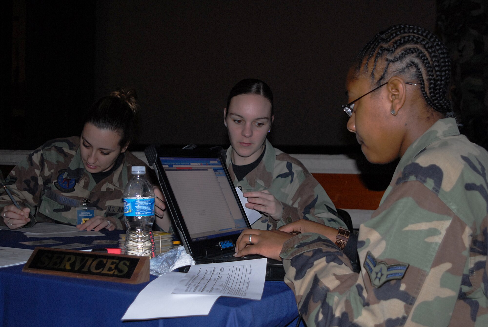 Airman 1st Class Tanya Blackburn, Senior Airman Arrin Lee, and Senior Airman Jessica Jackson, 18th Services Squadron, assign billeting arrangements for inbound forces at the reception processing unit during local operational readiness exercise Beverly High 08-4 at Kadena Air Base, Japan, Feb. 12, 2008. The 18th Wing conducted the exercise from Feb. 10 to 15 to test Airmen's ability to respond in contingency situations. (U.S. Air Force photo/Tech. Sgt. Anthony Iusi)