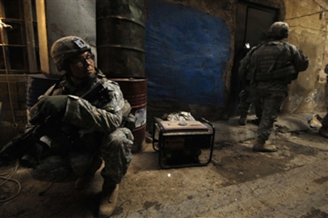 U.S. Army Spc. Eric Glowacki provides security as his fellow soldiers prepare to breach a house in a search of a possible improvised explosive device cache in Baghdad, Iraq, on Jan. 28, 2008.  Glowacki is a medic attached to the Armyís 3rd Platoon, Charlie Company, 1st Battalion, 504th Parachute Infantry Regiment.  