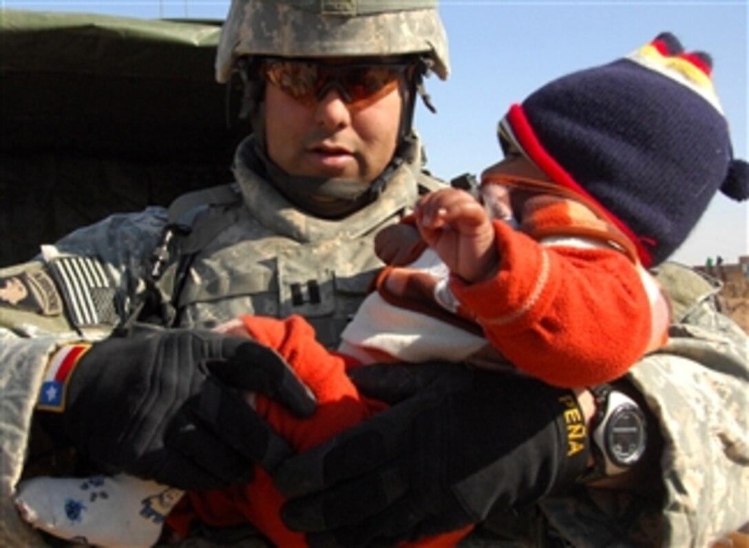 U.S. Army Capt. Joe Pena, a doctor and surgeon's assistant, examines an Iraqi child's leg during a medical operation in Jasmiyah, Iraq, Feb. 2, 2008. Pena is ssigned to 3rd Brigade Combat Team, 3rd Infantry Division.