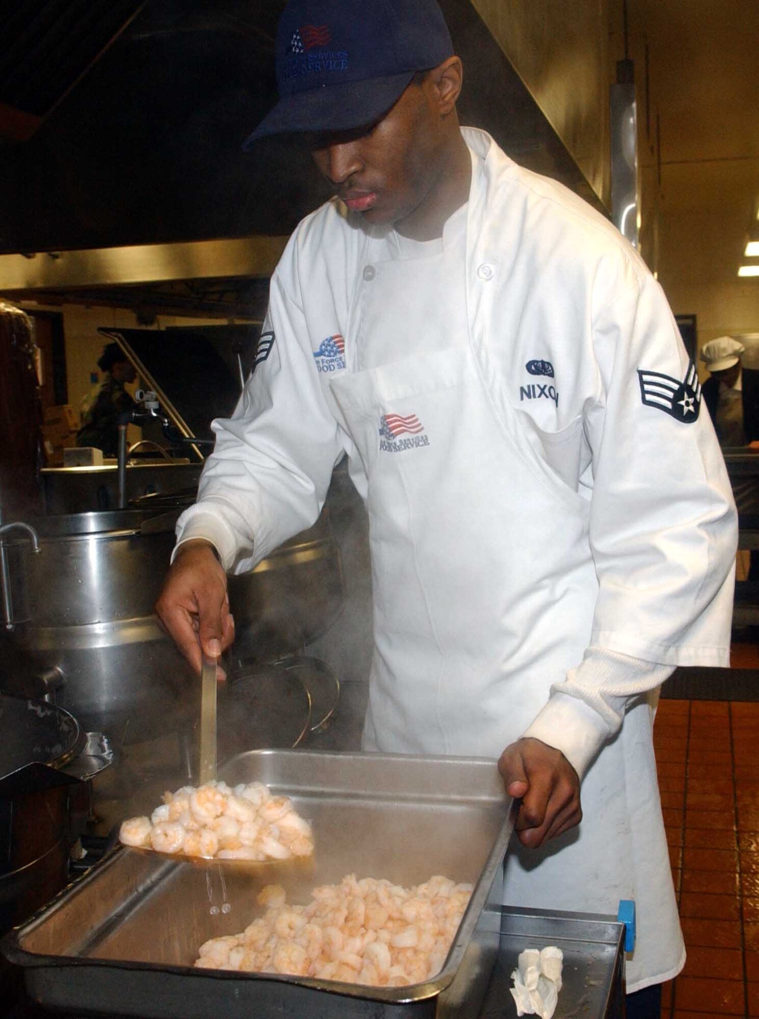 Senior Airman Antwon Nixon, 51st Services Squadron, ensure that the shrimp is fully cooked before serving as part of dinner meal preparation Feb. 12. The 51st Services Squadron Food Service flight must adhere to strict recipe guidelines and make certain all food is properly cooked. (U.S. Air Force photo by Staff Sgt. Candy Knight)