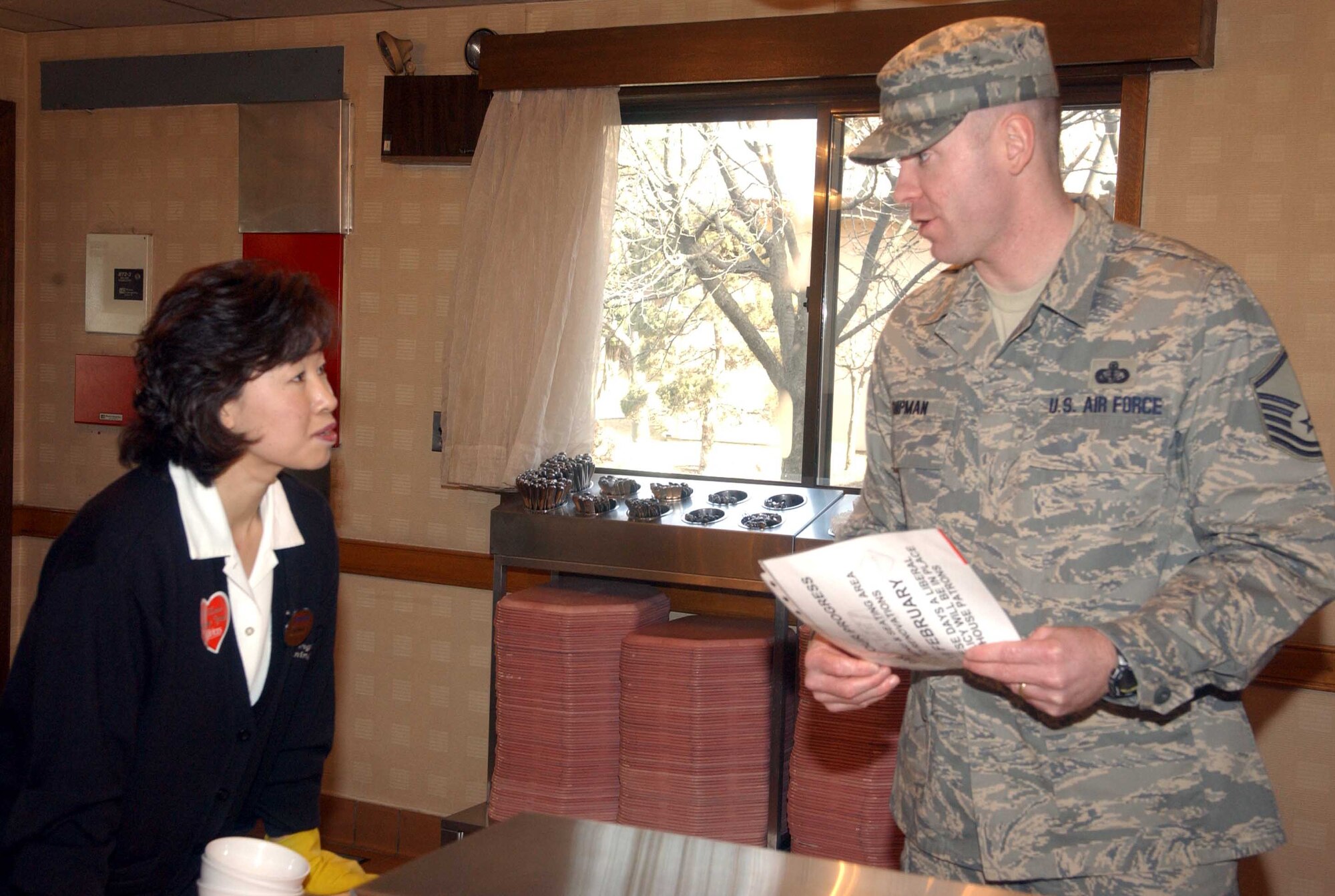 Master Sgt. Bryan Shipman, (left), Pacific House Dining Facility manager, discusses dining decorations with Ms. Yi, Hyon Ok Feb. 12. The 51st Services Squadron is preparing for the annual John L. Hennessy Award evaluation. The award, presented to the Air Force base with the best food service program, evaluates all aspects of a facility’s program including kitchen operations, serving and dining operations, training and readiness, sanitation and repair, and management. (U.S. Air Force photo by Staff Sgt. Candy Knight)