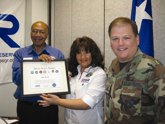 Ms. Talia Wesley, ESGR volunteer, smiles for the camera as she receives the Seven
Seals Award. Major Gen. (Ret.) Peter J. Gravett, California ESGR Chairman, and Major Donald Traud, 452nd AMW Public Affairs, congratulate Ms. Wesley.  (U.S. Air Force photo by Blanche Gravett)