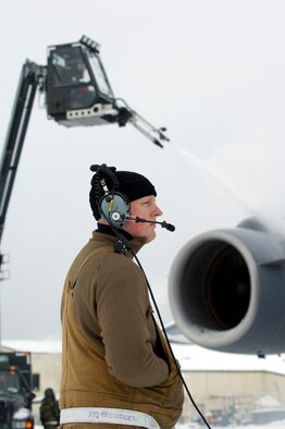 Airman 1st Class Phillip Gudgel, a C-17 crew chief from the 703rd Aircraft Maintenance Squadron, watches de-iceing procedures before the aircraft taxis for a training mission. Heavy snow and weeks of sub-zero temperatures require extra effort from maintenance crews to keep the aircraft clear of ice and snow. The training mission included dropping Army Airborne Soldiers from Fort Richardson, Alaska, and conducting air drops of training bundles that simulate the Soldier's equipment. (U.S. Air Force photo/Master Sgt. Keith Brown)