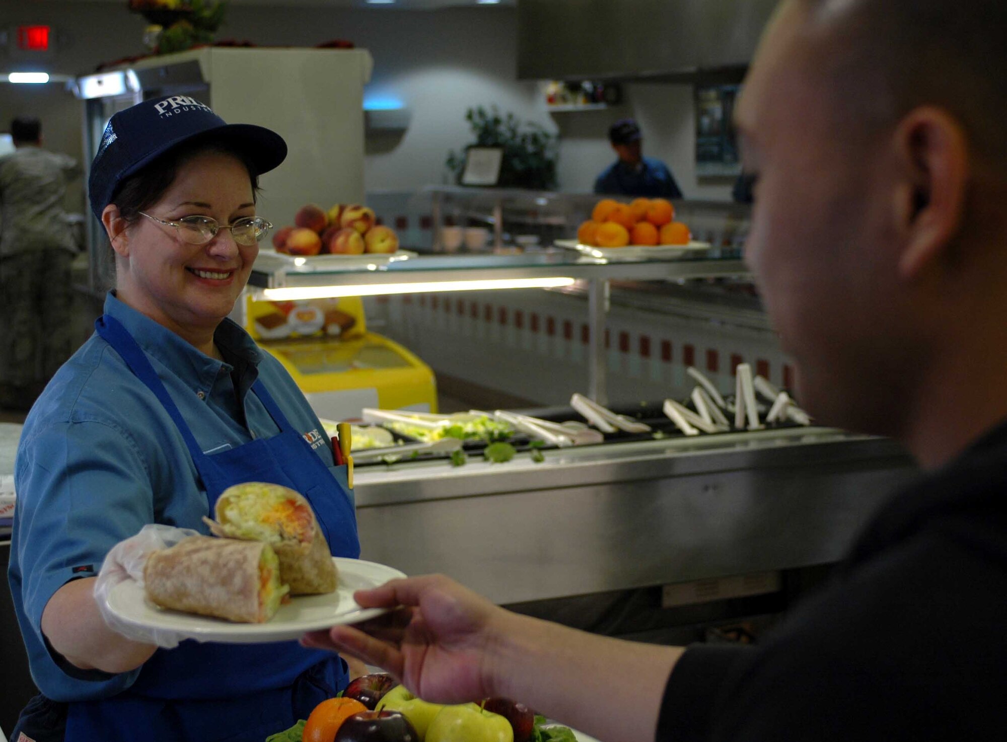 Patricia Wagner, Sierra Inn Dining Facility deli bar clerk, serves Airman 1st Class Jonathan Malumay, 60th Logistics Readiness Squadron, his food recently. The food service staff are preparing for the Hennessy Award inspection, scheduled for Feb. 18 to 19. The award honors the service's best dining facility. (U.S. Air Force photo/Senior Airman Shaun Emery)