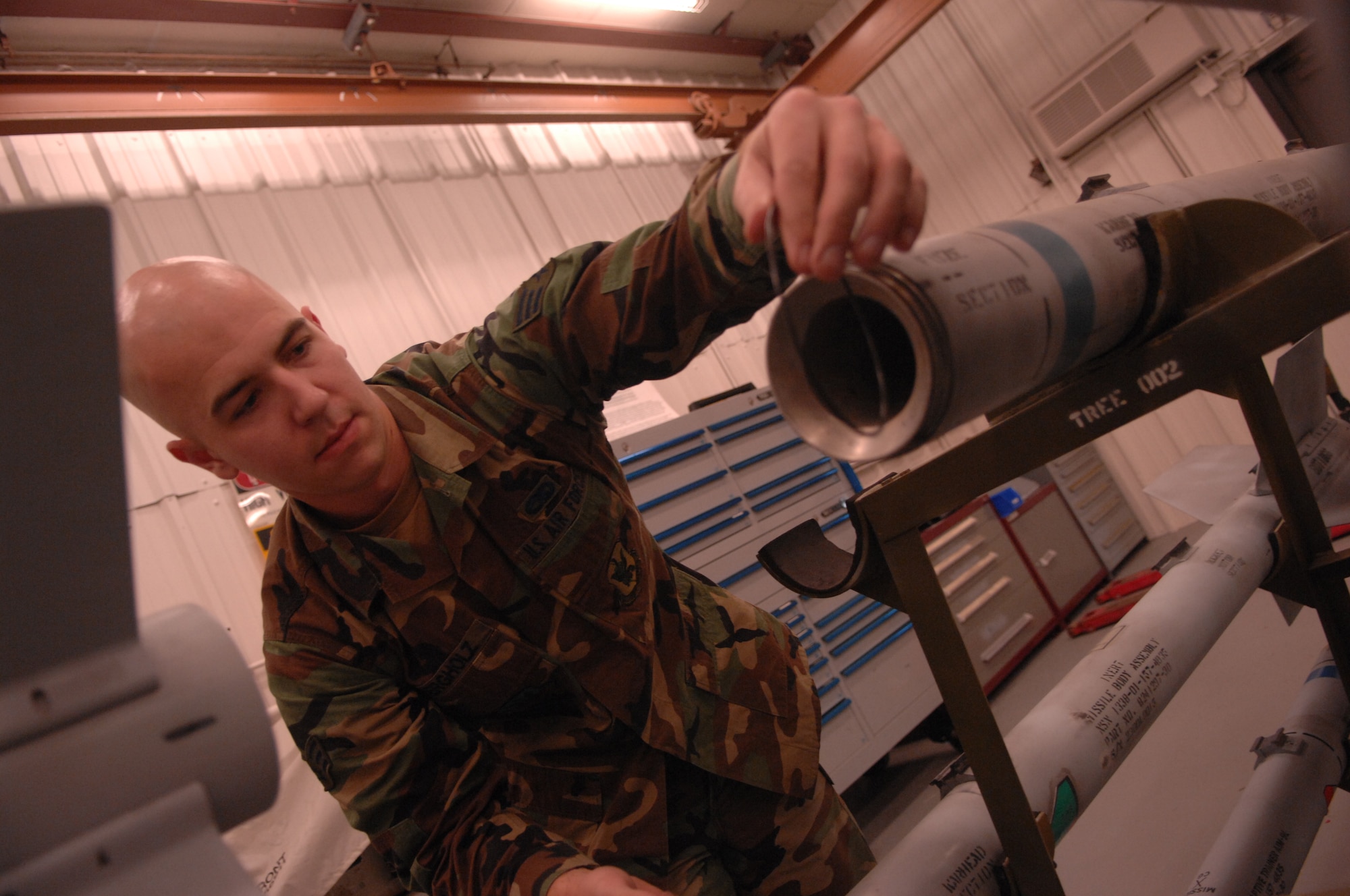 MOODY AIR FORCE BASE, Ga. -- Senior Airman Trevor Bergholz, 23rd Equipment Maintenance Squadron precision guided munitions crew member, works on the missile body of an AIM-9 Sidewinder Captive Air Training Missile here Feb. 13. Bergholz is preparing the body of the inert missile to connect the live guidance section. (U.S. Air Force photo by Airman 1st Class Gina Chiaverotti)