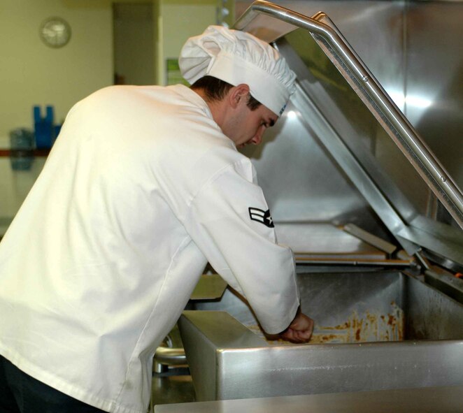 Airman 1st Class Jeffrey Michal, food service apprentice, cleans in the Sierra Inn Dining Facility kitchen recently. Airman Michal and the food service staff are preparing for the Hennessy Award inspection, scheduled Feb. 18 to 19. The Hennessy Award honors the service’s best dining facility. (U.S. Air Force photo/Nick DeCicco)
