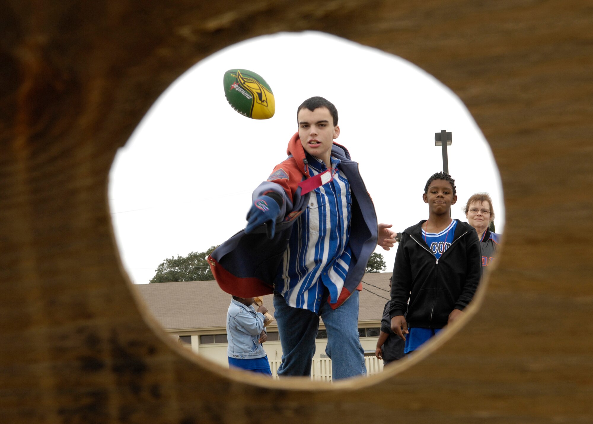 EGLIN AIR FORCE BASE, Fla. -- An athlete attempts to toss a football into a hole during the carnival of the 2008 Northwest Sectional basketball tournament held here Feb. 10. More than 350 athletes and coaches from Okaloosa, Walton, Jackson, Gadsden, Leon, Hamilton, Columbia, Escambia and Taylor counties participated in the sectional tournament. (U.S. Air Force photo by Debbie Haussermann)