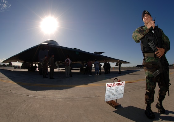HICKAM AIR FORCE BASE, Hawaii-- During a clear day, Senior Airman Robert Palalaya, 15th Security Forces Squadron stands guard at the entry control point for the B-2 Spirit during a media event. The 393rd Expeditionary Bomb Squadron, stationed at Whiteman Air Force Base, Mo., is currently wrapping up it's deployment as a continuous bomber presence at Andersen Air Force Base, Guam. The B-2's low observability provides greater freedom of maneuver whle high altitiude flight increases its range and provides a better field of view for the aircraft's sensors. (U.S. Air Force photo by Vanessa M. Perez)