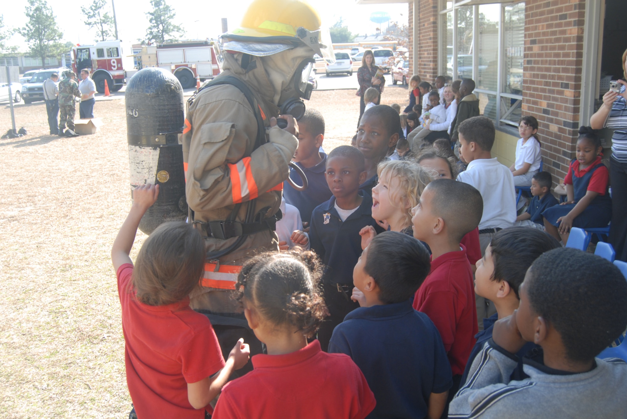 Airman 1st Class Wendell Washington-Flournoy, Pope Fire Department, talks with students at Manchester Elementary School in Spring Lake, N.C. while they come in for a closer look at his fire gear during Pope Fire's visit to the school Feb. 5. (U.S Air Force Photo by 2nd Lt. Chris Hoyler)