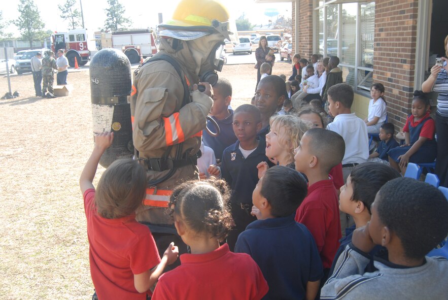 Airman 1st Class Wendell Washington-Flournoy, Pope Fire Department, talks with students at Manchester Elementary School in Spring Lake, N.C. while they come in for a closer look at his fire gear during Pope Fire's visit to the school Feb. 5. (U.S Air Force Photo by 2nd Lt. Chris Hoyler)