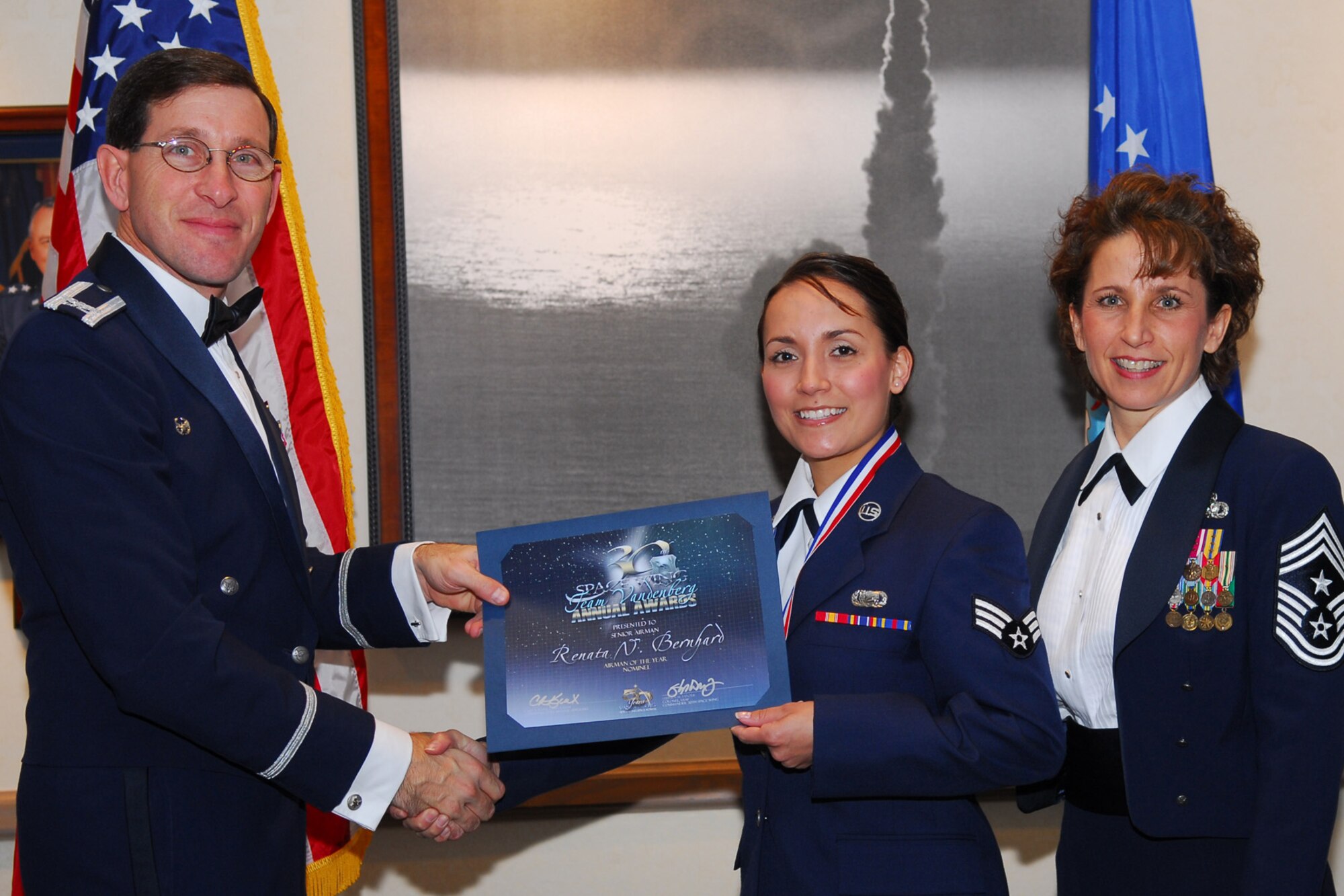 VANDENBERG AIR FORCE BASE, Calif. -- Senior Airman Renata Bernhard, 30 Launch Support Squadron, receives a certificate as an annual award nominee from Col. Steve Tanous and Command Chief Master Sgt. Cari Kent during the Annual Awards ceremony on Feb. 1, at the Pacific Coast Club. Senior Airman Bernhard was nominated for Airman of the Year, representing the 30th Launch Group. The awards ceremony was held to honor the annual award winners from Vandenberg's associate units, the 30th Space Wing, and the overall winners for the base, more commonly known as Team Vandenberg. (U.S. Air Force photo/Senior Airman Ashley Hawkins)