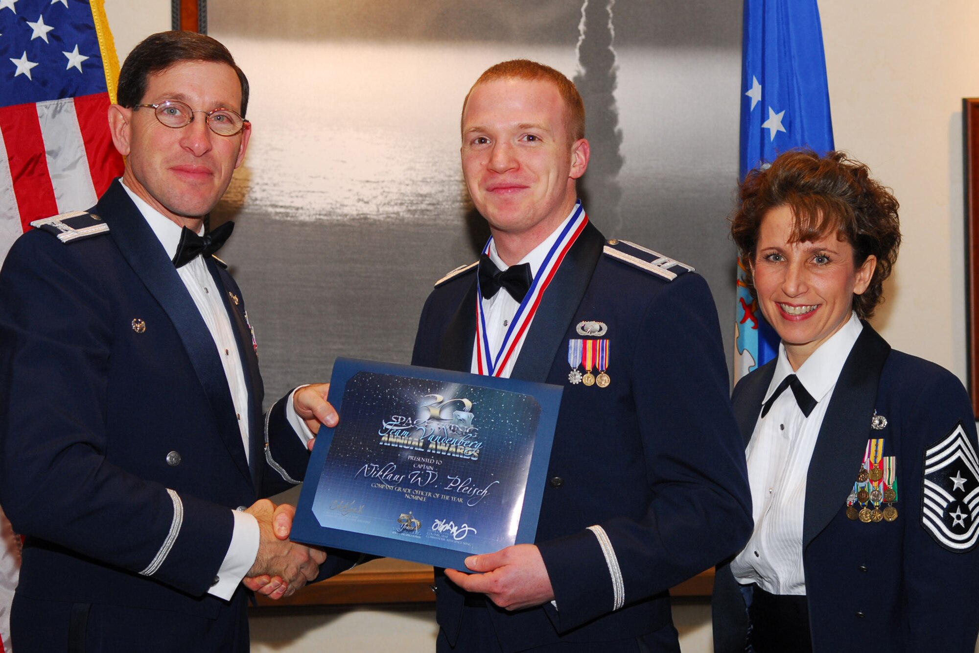 VANDENBERG AIR FORCE BASE, Calif. -- Capt. Niklaus Pleisch, a 30th Comptroller Squadron, receives a certificate as an annual award nominee from Col. Steve Tanous and Command Chief Master Sgt. Cari Kent during the Annual Awards ceremony on Feb. 1, at the Pacific Coast Club. Capt. Pleisch was nominated for Company Grade Officer of the Year, representing the 30th Space Wing-Wing Staff Agency. The awards ceremony was held to honor the annual award winners from Vandenberg's associate units, the 30 space wing, and the overall winners for the base, more commonly known as Team Vandenberg. (U.S. Air Force photo/Senior Airman Ashley Hawkins)