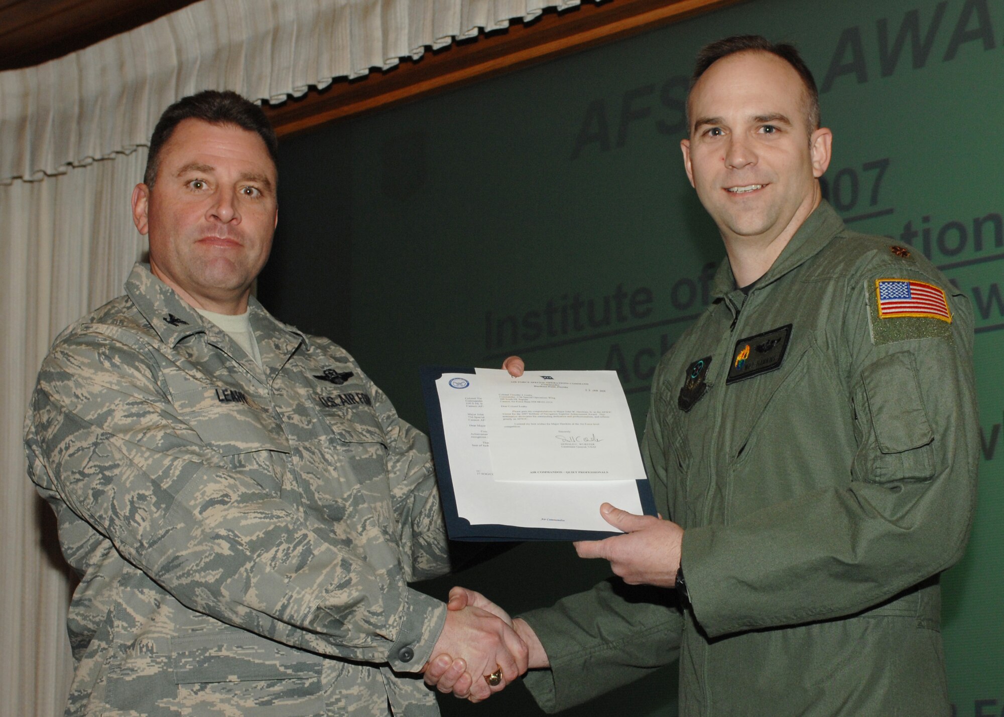 CANNON AIR FORCE BASE, N.M. --  Col. Timothy Leahy presents Maj.John Hawkins with the Institute of Navigation Superior Achievement Award Feb. during the wing staff meeting. Maj. Hawkins is assigned to the 73rd Special Operations Squadron.  (Air Force photo by A1C James R. Bell)