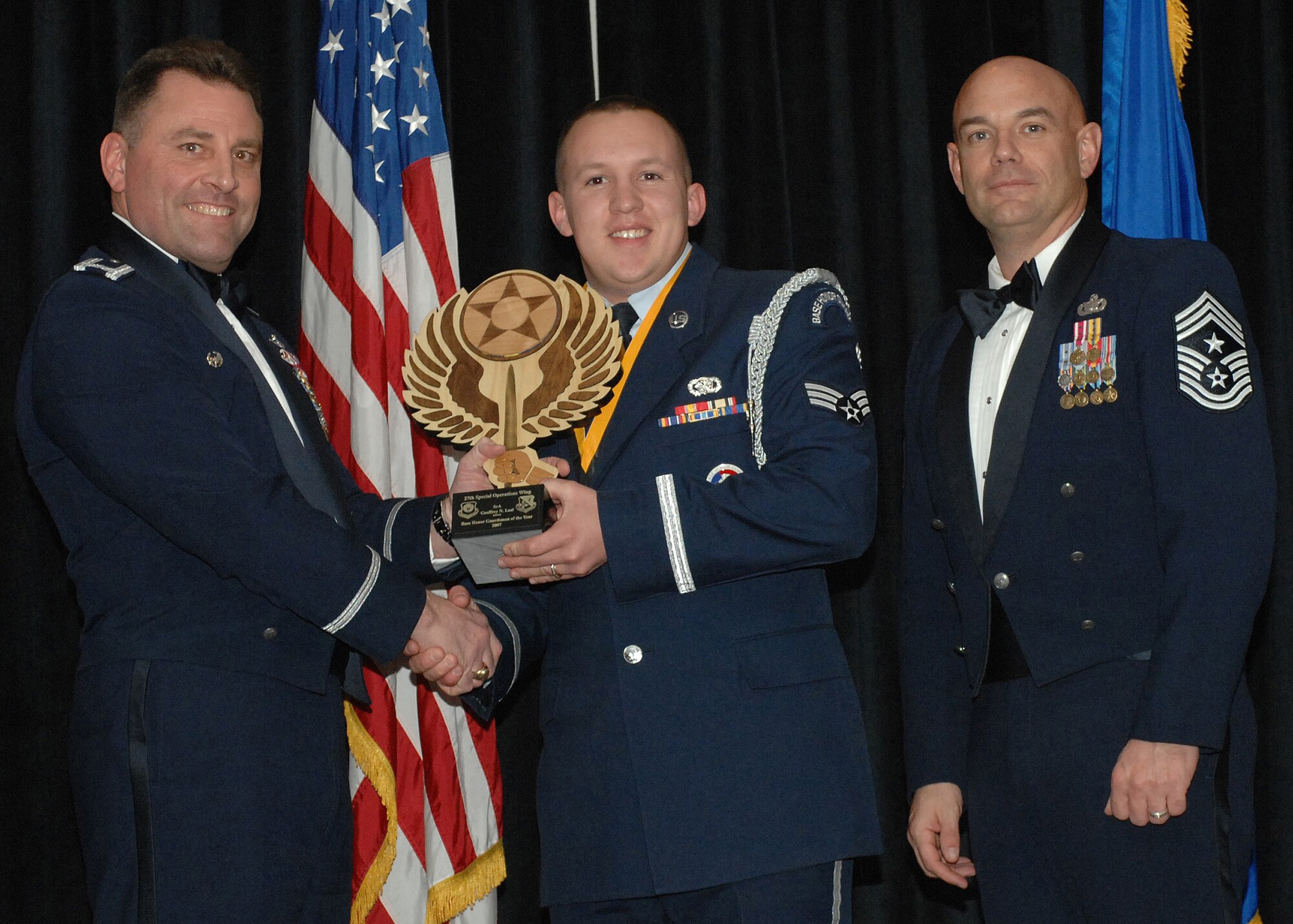 CANNON AIR FORCE BASE, N.M. -- Colonol Timothy Leahy and Chief Master Sergeant Daniel Fischer presents Senior Airman Geoffrey Leal with Base Honor Guardsman of the Year on Feb 9 at the Wing Annual Awards dinner at The Landing.  Airman Leal is assigned to the 27th Special operations Mission Support Group.  (U.S. Air Force photo by A1C James R. Bell)