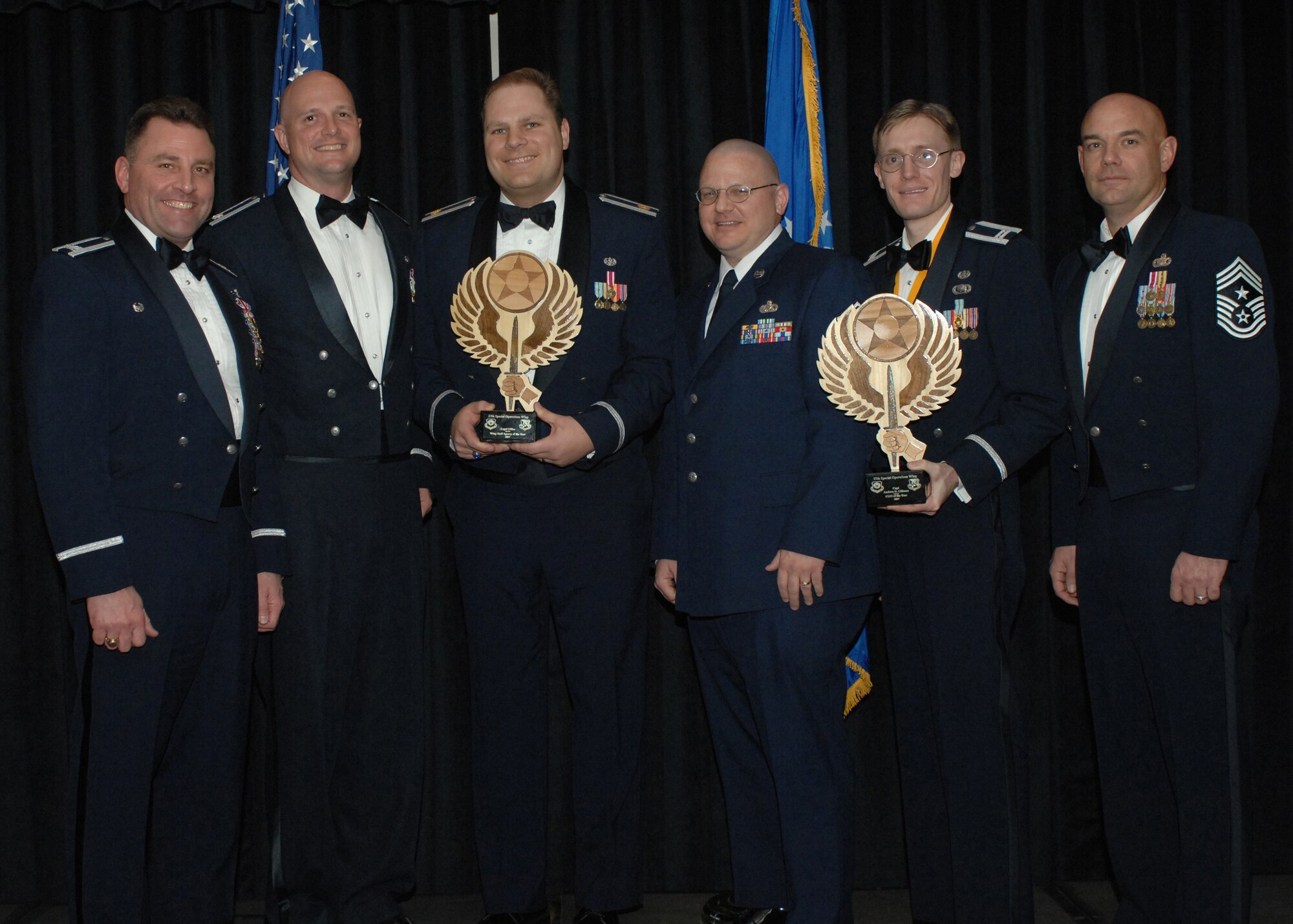CANNON AIR FORCE BASE, N.M. -- Maj. Josephi Imburgia, 27th Special Operations Wing Judge Advocate Office, third from left, holds the 27th Special Operations Wing  Staff Agency of the Year trophy presented by Col. Timothy Leahy, 27SOW commander, on Feb. 9. Capt. Andrew GIllman, 27SOW/JA, displays the Company Grade Officer of the Year trophy presented to him during the wing annual awards dinner.  (U. S. Air Force photo by A1C James R. Bell)