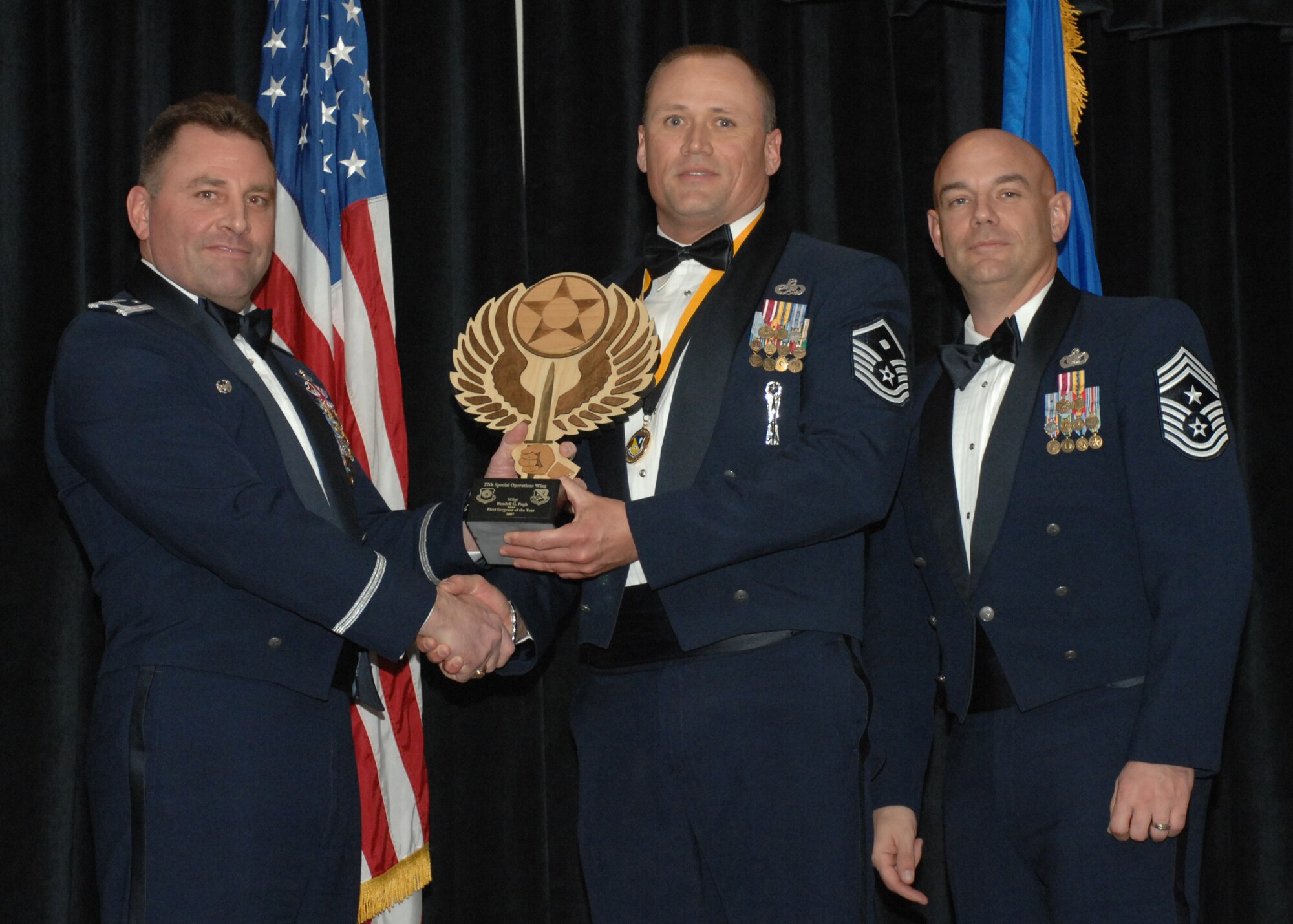 Cannon Air Force Base N.M. -- Col. Timothy Leahy, 27th Special Operations Wing commander (left), and Chief Master Sgt. Daniel Fischer, wing command chief, present Master Sgt. Wendell Pugh with the award for First Sergeant of the Year on Feb. 9, 2008 at The Landing.  Sergeant Pugh is from the 27th Special Operations Group.  (U.S. Air Force photo/A1C James R. Bell)