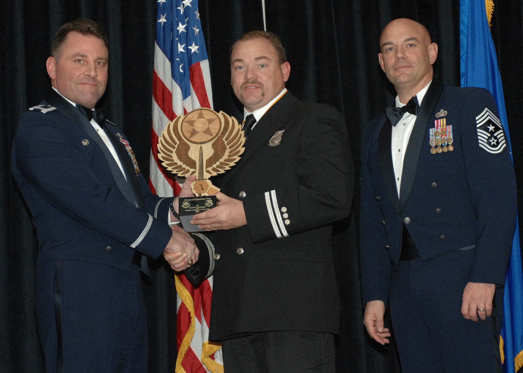 Cannon Air Force Base N.M.- Col.Timothy Leahy, 27th Special Operations Wing commander (left), and Chief Master Sgt. Daniel Fischer, wing command chief, present Kevin Herrington with the award for Civilian Employee of the Year, Category One on Feb. 9.  Mr. Herrington is from the 27th Special Operations Mission Support Group.  (U.S. Air Force photo/A1C James Bell)