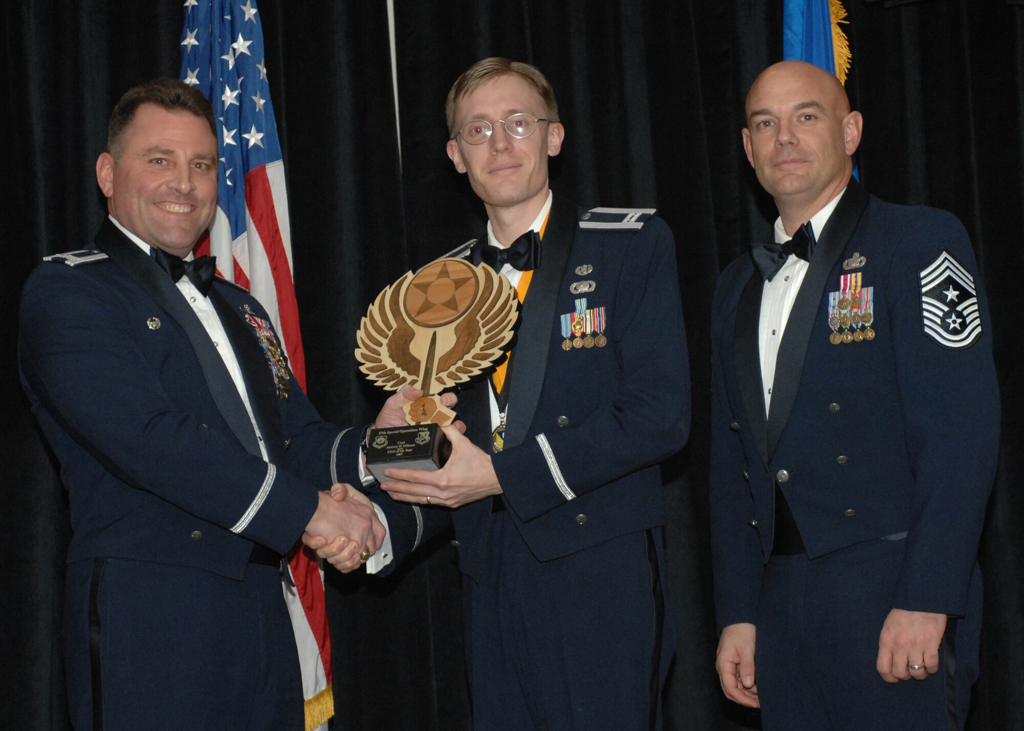 Cannon Air Force Base- Col. Timothy Leahy, 27th Special Operations Wing commander (left), and Chief Master Serg. Daniel Fischer, wing command chief, presents Capt. Andrew Gillman with the award for Company Grade Officer of the Year on Feb. 9, 2008. Captain Gillman is from the 27th Special Operations Wing Staff.  (U.S. Air Force photo/A1C James R. Bell)