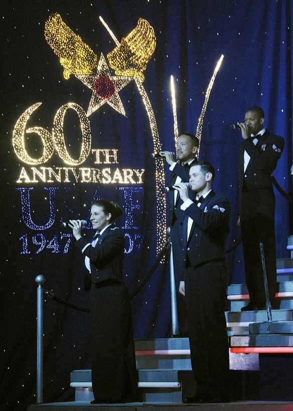 Vocalists from the Air Force's permier enterainment troupe Tops In Blue perform in front of an Air Force 60th Anniversary backdrop Feb. 9, honoring the services legacy of air superiority since 1947. The group performed at Memorial Auditorium in Wichita Falls, Texas, an annual tour stop for the group. Tops In Blue performed songs that coincide with different eras of the military. (U.S. Air Force photo/Harry Tonemah)