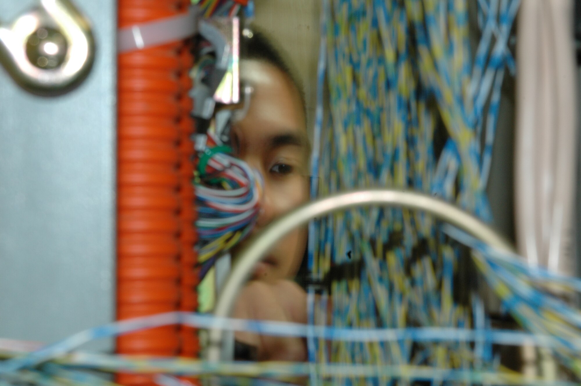 2nd Lt. John Bernabe, 60th Communications Squadron, inspects cables in the control room of the telephone systems building. The office has adopted several new technologies, including one which automatically protects the base against unauthorized faxes and war dialers. (U.S. Air Force photo/Nick DeCicco)