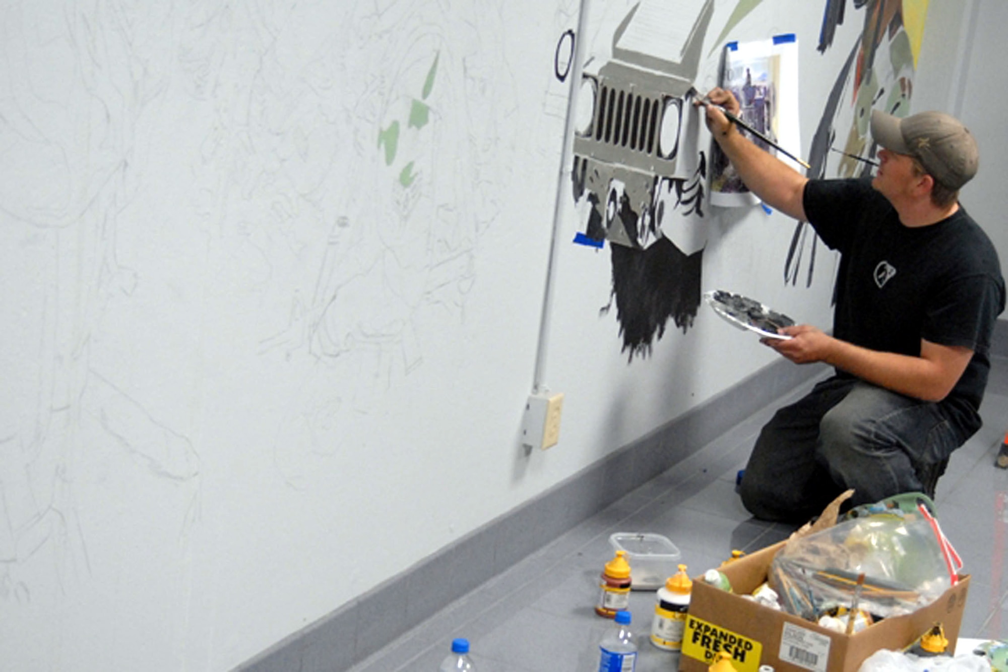 Bobby Stillwell paints a HUMVEE on the wall of the 341st Security Forces Group headquarters during one of his visits to Malmstrom from Wenatchee, Wash. He is the son of Bob Stillwell, 341st Communications Squadron contracted graphic artist, who volunteered more than 230 hours painting a security forces-themed mural. The Stillwell's began painting the mural in August 2007 and plan to continue producing more murals throughout 2008. (U.S. Air Force photo) 
