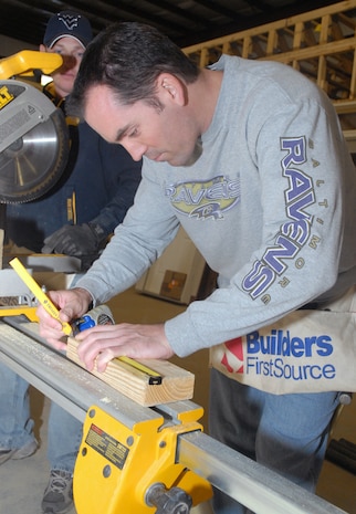 Master Sgt. Troy Brawner, 437th Aerial Port Squadron, measures and marks the required length on a piece of wood before cutting it at the Top 3-sponsored Habitat for Humanity project in Summerville, S.C. (U.S. Air Force photo/Master Sgt. Paul Kilgallon)