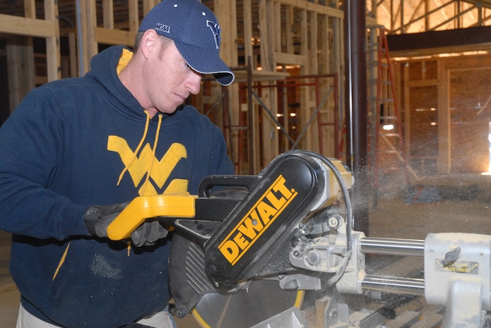 Tech. Sgt. Jody Miller, 437th Aerial Port Squadron, uses a mitre and table saw to cut a section of wood Feb. 8 at the Top 3-sponsored Habitat for Humanity project in Summerville, S.C. More than 20 Airmen from both the 437th and 315th Airlift Wings participated in the event. (U.S. Air Force photo/Master Sgt. Paul Kilgallon)