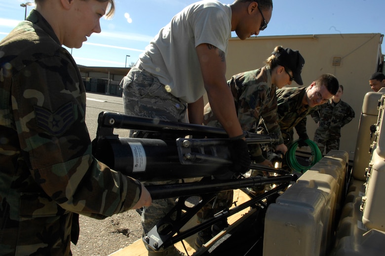 (From left to right) Staff Sgt. Sue Thompson, Senior Airman William Radford, Tech. Sgt. Melissa Moller, and Airman 1st Class Alden Newgard, all from the 612th Air Communications Squadron satellite communications shop, prepare the tripod for the USC-60 Jan. 28. The antenna is mounted onto the tripod to provide tactical satellite communications. (U.S. Air Force photo by Senior Airman Jesse Shipps)