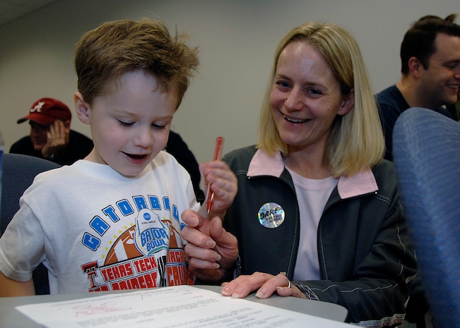 Colin Shiflett, 3, and his mother, Deb, go through one of the workbooks together that the children received at the family deployment line on Charleston AFB Feb. 9.  The family deployment line was a way for the children and families of military members to see what occurs before a deployment. (U.S. Air Force photo/Airman 1st Class Katie Gieratz)
