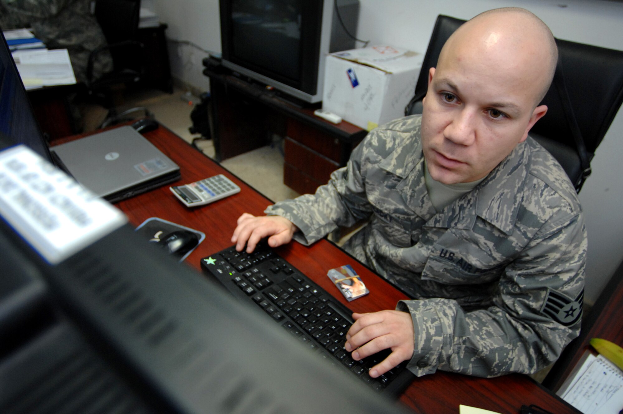 BALAD AIR BASE, Iraq -- Staff Sgt. Christopher Hladky, 332nd Air Expeditionary Wing financial manager, inputs Eagle Cash card information into the Financial Management Office's computer system here, Feb. 11. The Air Force adopted the program, which gives personnel an alternative to using their debit cards and checks, in early November 2007. Currently, approximately 50 cards are issued each day to military personnel here. Sergeant Hladky is deployed from Hanscom Air Force Base, Mass. (U.S. Air Force photo/ Senior Airman Julianne Showalter)