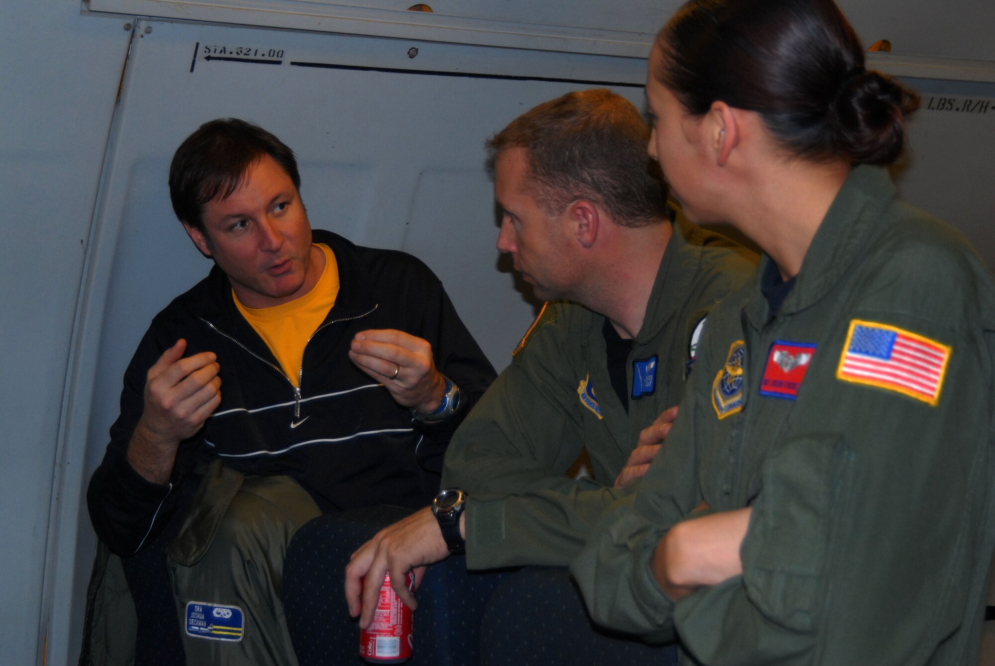 Tim Gilmore, (left) Air Force account director at GSD&M, the Air Force's contracted advertising agency in Austin, Texas, talks with Tech. Sgt. Mike O'Conner from Edwards Air Force Base, Calif., and Staff Sgt. Lucero Stockett, a KC-10 Extender boom operator from Travis AFB, Calif. Film crews were on board the Travis KC-10 filming an aerial refueling of an Edwards F-22 Raptor. The filming is part of three new commercials the Air Force is having filmed to showcase the Air Force's Global Reach capabilities. (Air Force Photo by Master Sgt. Eric M. Grill)
