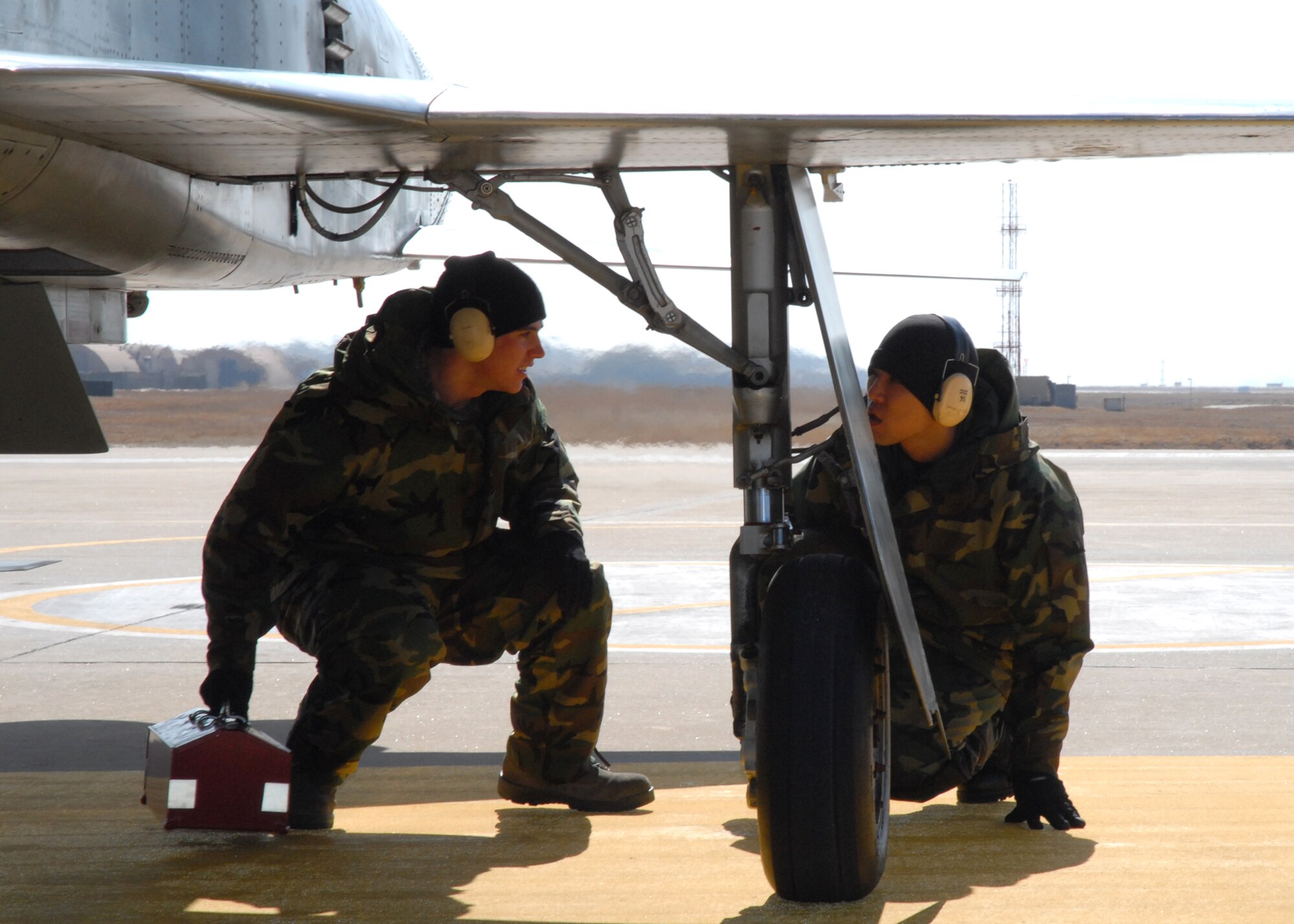 KUNSAN AIR BASE, South Korea— Senior Airman Tyler Brown and Staff Sgt. John Kim 8th Maintenance Group weapons, do visual checks of a Republic of Korea Air Force F-5 here Feb. 13.  This event was a part of cross servicing aircraft for training purposes by the ROKAF and the 8th Fighter Wing. (U.S. Air Force Photo/Staff Sgt Araceli Alarcon) 