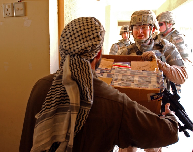 CAMP BUCCA, Iraq – Second Lt. John Bergmans, Jester 1-2, 887th Expeditionary Security Forces Squadron, hands an Iraqi teacher school supplies in Safwan, Iraq, on Feb. 7, 2008. The donation is part of an area-wide effort near Camp Bucca to aid the surrounding citizens in maintaining their newly returned province. Al-Basra became the ninth province in Iraq to be transitioned to Iraqi provincial control in January. Lieutenant Bergmans is deployed from Moody Air Force Base, Ga. (U.S. Army photo/Spc. Brandon Hubbard, 300th MP BDE)