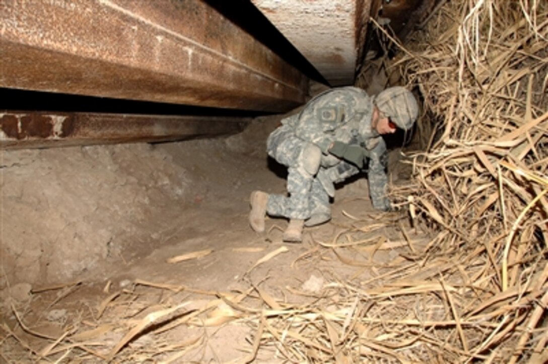 A U.S. Army soldier searches for a weapons cache and evidence of insurgency in a man-made cave in Muqdadiyah, Iraq, on Feb. 8, 2008.  The soldier is from Alpha Company, 2nd Battalion, 23rd Infantry Regiment, 4th Brigade Combat Team, 2nd Infantry Division.  
