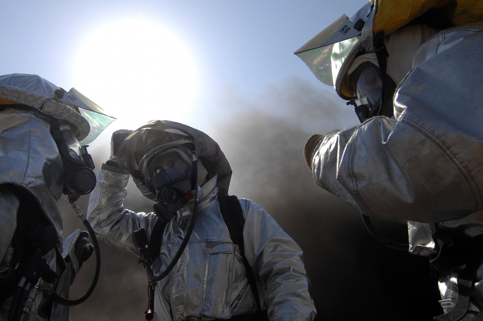 Members of the 447th Air Expeditionary Group's fire department don protective equipment during joint training with the Baghdad International Airport fire department at BIAP Feb. 12. During training, the organizations joined to extinguish a controlled fire inside an abandon building. The joint training solidifies an established relationship between the organizations and introduces the new rotation of U.S. Airmen to their Iraqi counterparts. (U.S. Air Force photo/Tech. Sgt. Jeffrey Allen)