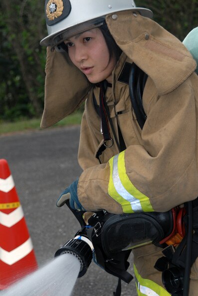 Yuki Uechi, Nirai Fire Department, uses a hose to rinse off fellow firefighters before they move through a chemical transition point during a joint training exercise at Kadena Air Base, Japan, Feb. 14, 2008.  These joint training exercises allow Kadena and Nirai fire department personnel to gain further understanding of each other's skills, and foster a better working relationship. (U.S. Air Force photo/Staff Sgt. Christopher Marasky)