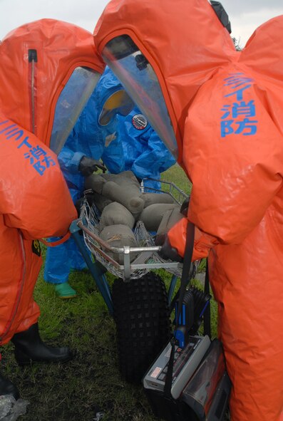 Members of the Kadena Fire Department (wearng the blue hazardous material suit) and the Nirai Fire Department (orange suits),  evacuate a simulated victim during a joint training exercise at Kadena Air Base, Japan, Feb. 14, 2008.  These joint training exercises allow Kadena and Nirai fire department personnel to gain further understanding of each other's skills, and foster a better working relationship. (U.S. Air Force photo/Staff Sgt. Christopher Marasky)
