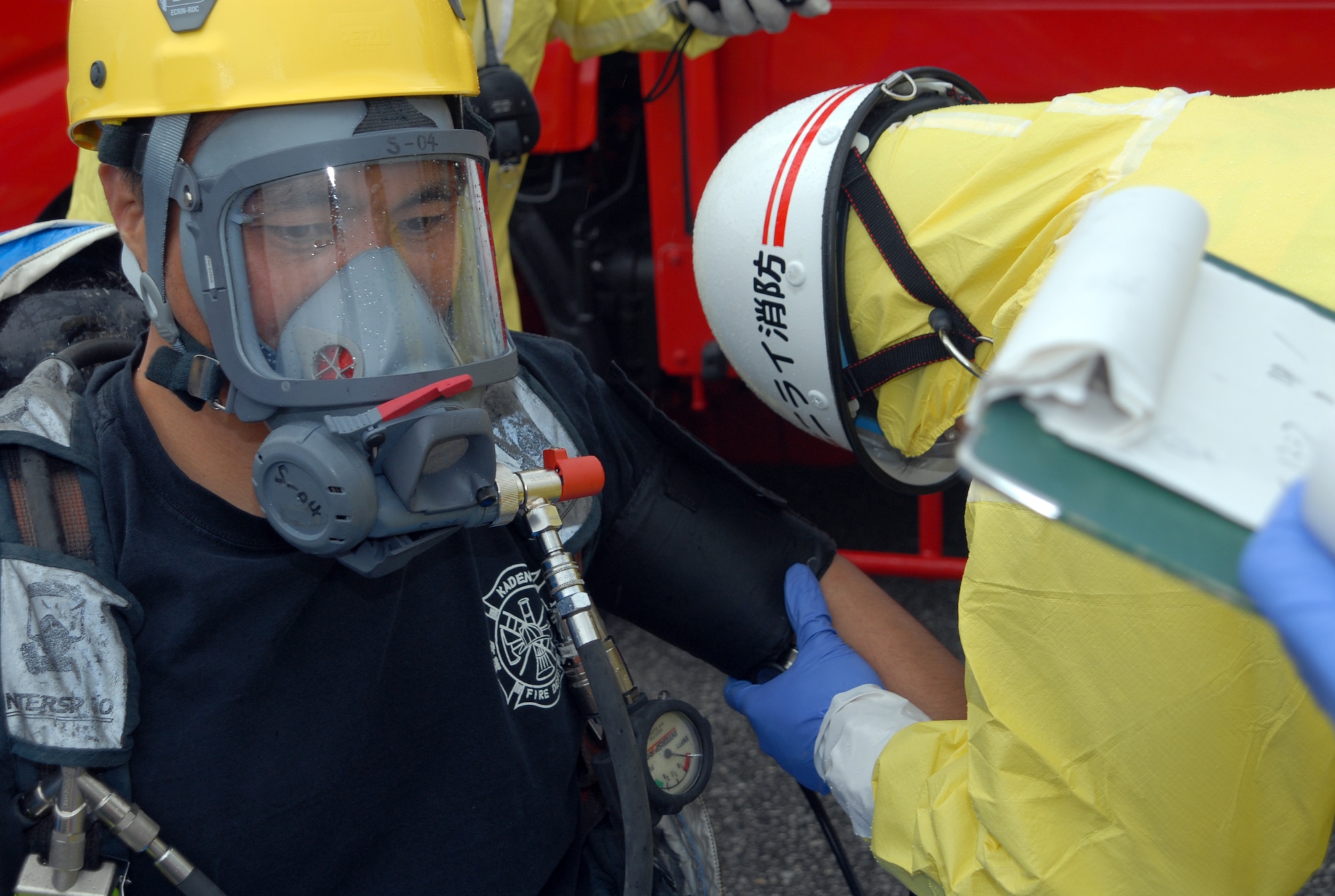 Members of the Nirai fire department check the vital signs of a Kadena firefighter before he puts on his hazardous material suit and heads into a simulated accident scenario during a joint training exercise at Kadena Air Base, Japan, Feb. 14, 2008.  These joint training exercises allow Kadena and Nirai fire department personnel to gain further understanding of each other's skills, and foster a better working relationship. (U.S. Air Force photo/Staff Sgt. Christopher Marasky)
