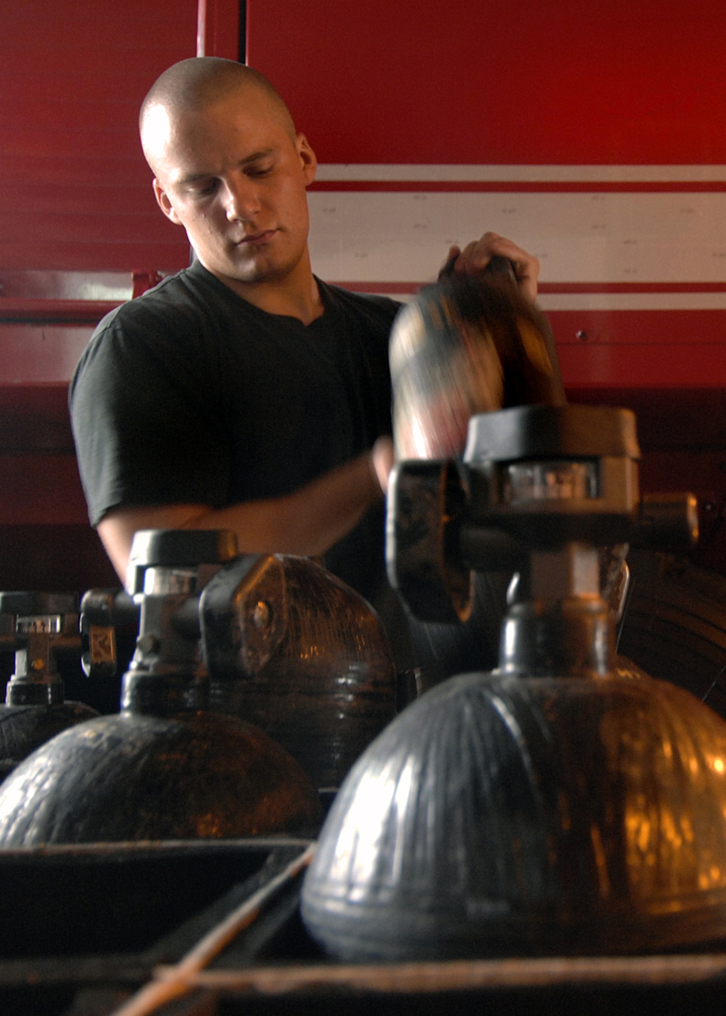 Andersen AFB, Guam -- Senior Airman Aaron Huddle, 36th Civil Engineer Squadron inspects self contained breathing apparatus tanks during his morning checks. The breathing tanks are used to supply oxygen to the fire fighters as they fight fires so they must be maintained and in working order at all times. Andersen's fire department trains every day to respond to emergencies 24 hours a day seven days a week.
(U.S. Air Force Photo By Staff Sgt. Vanessa Valentine) 