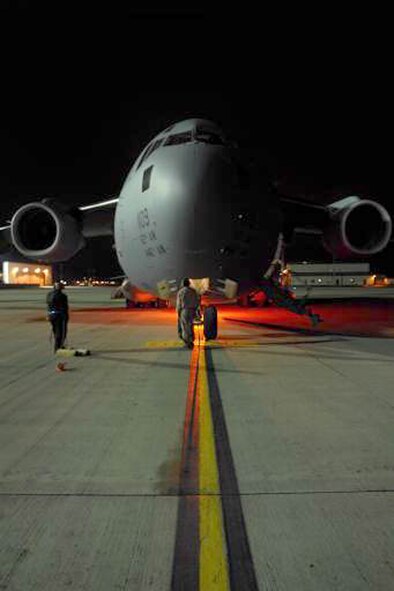 A C-17 Globemaster III aircraft from McChord Air Force Base, Wash., reaches its parking spot and is prepared for cargo offload Dec. 13, 2007, at Ramstein Air Base, Germany. In January 2009, Reservists from the 446th Airlift Wing, McChord will provide direct support from Ramstein AB, for airlift requirements in the European and African areas of operation. (U.S. Air Force photo/Airman First Class Kenny Holston) 