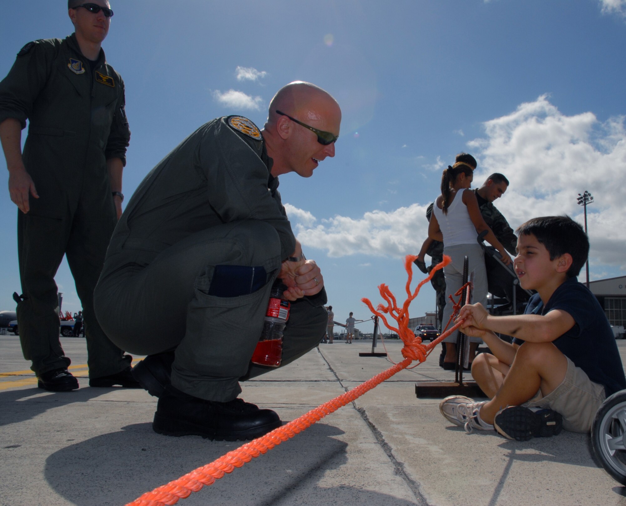 Maj.  Geoff Rowanowicz,  393rd Expeditionary Bomb Squadron,  Andersen AFB, Gaum  kneels down to talk with 5 year-old Jake Neslony, the son of 2nd Lt. Timothy Neslony assigned to Air Combat Command 561 Network Operations Site Detachment 1. Major Rowanowicz  is part of the aircrew and support personnel that are redeploying back to the 509th Bomb Wing at Whiteman Air Force Base, Mo.  Military and family members were given the opportunity to view the B-2 Spirit Stealth bomber Feb. 12, 2008 on the Hickam flightline. (U.S. Air Force photo/Master Sgt.  Robert Burgess)
