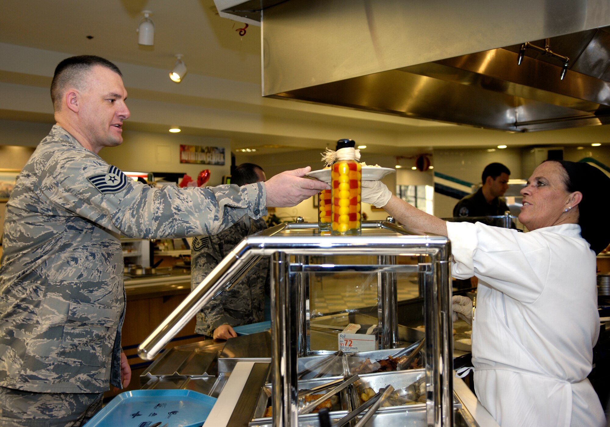 VANDENBERG AIR FORCE BASE, Calif. -- Tech. Sgt. John Thiel, 14th Air Force, is served by Lori Zirkle, a LOVARC employee, at Breakers Dining Facility on Feb. 14. The John L. Hennessy Award team will visit here Feb. 22-25. The Hennessy trophy is the highest Air Force award given for excellence in food service. (U.S. Air Force photo by Airman 1st Class Jonathan Olds)