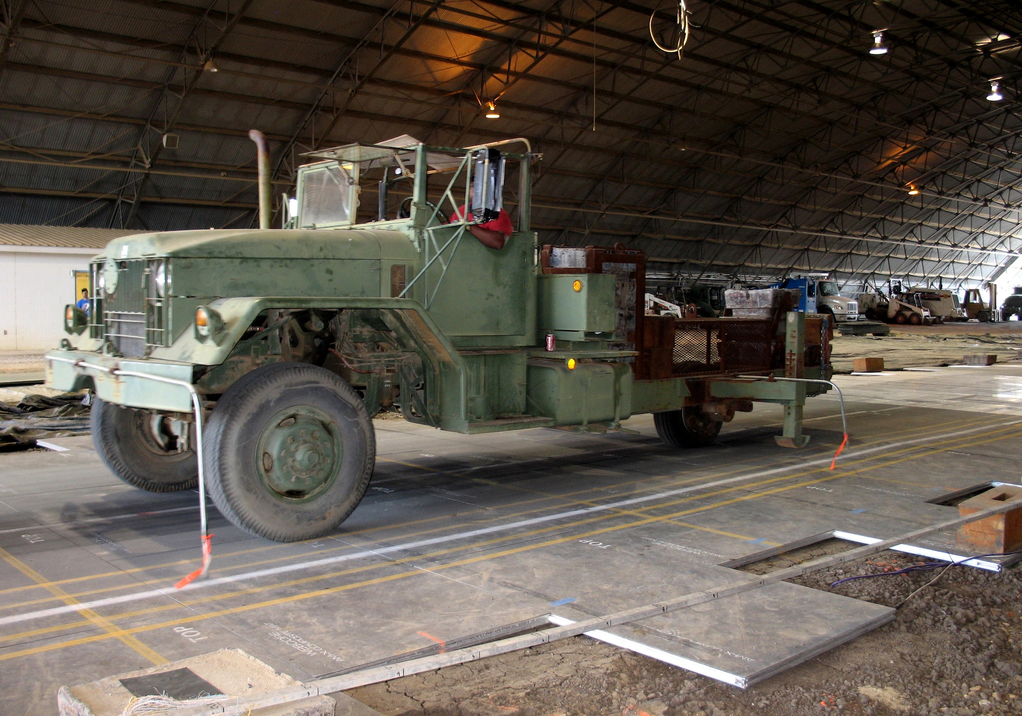 A vehicle tests lightweight composite airfield matting that speeds up forward aircraft deployments, expands parking space and reduces costs. Working in partnership with the civilian industry, Air Force engineers have developed lightweight composite next generation panels to support aircraft as airfield matting at austere airfields. (U.S. Air Force photo) 
