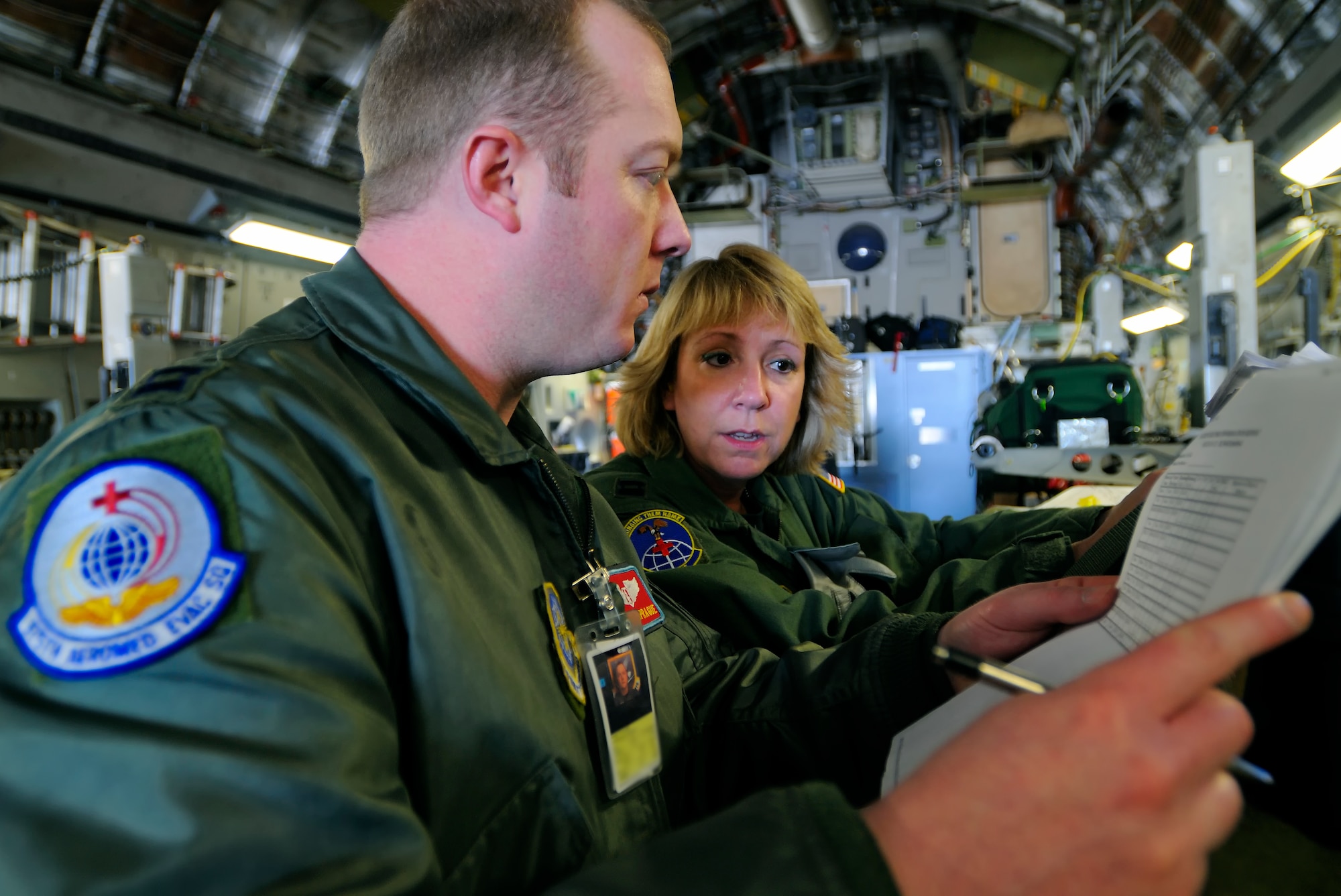 SCOTT AIR FORCE BASE, Ill. -- Capt. Mark Sprague, 375th Aeromedical Evacuation Squadron flight nurse, is briefed by Capt. Lisa Giugliano, 89th AES flight nurse, on patients before they are transferred to a C-130 aircraft Feb. 9 at Scott AFB, Ill. The 375th Airlift Wing located at Scott is one of three Aeromedical Staging Facility distribution hubs in the continental United States that is responsible for transporting patients to their home bases or other specialized hospitals. (U.S. Air Force photo/Master Sgt. Maurice Hessel)