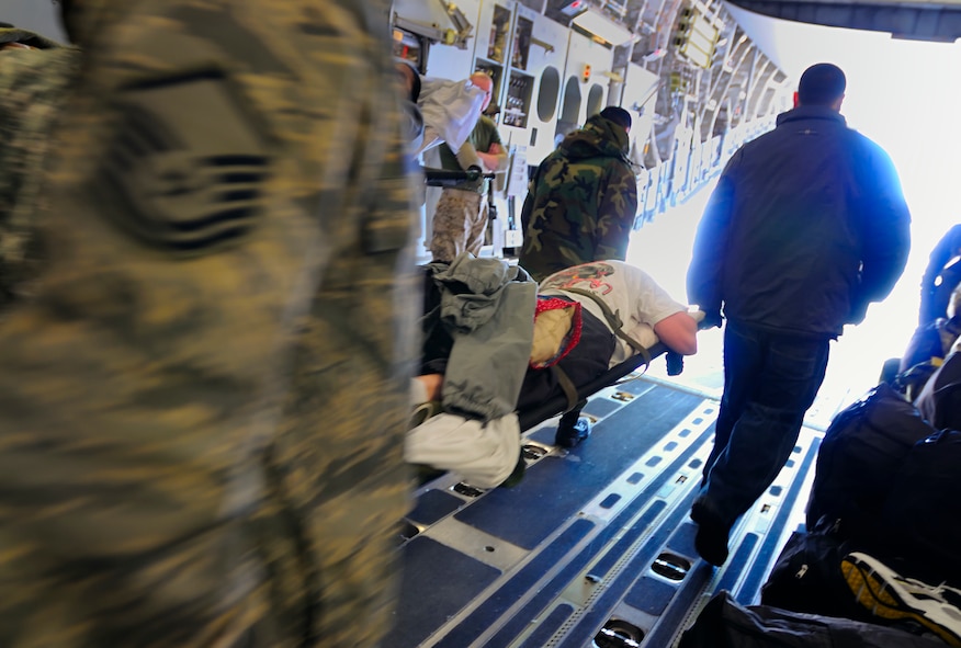 SCOTT AIR FORCE BASE, Ill. -- 375th Aeromedical Staging Facility medical technicians transfer a patient off a C-17 aircraft  to a C-130 or ASF room Feb.9 at Scott AFB, Ill. The 375th Airlift Wing located at Scott is one of three ASF distribution hubs in the continental United States that is responsible for transporting patients to their home bases or other specialized hospitals. (U.S. Air Force photo/Master Sgt. Maurice Hessel)