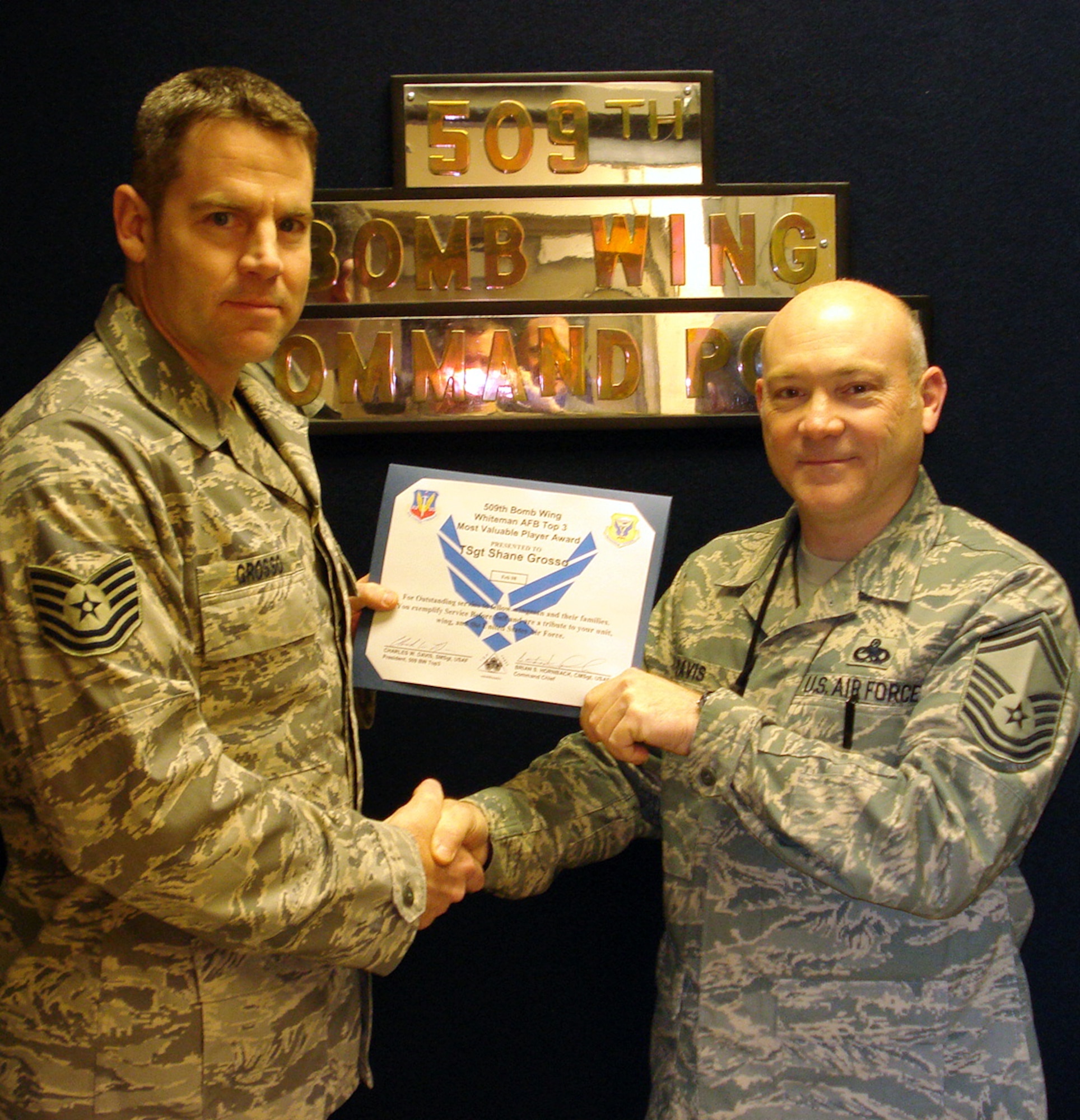 WHITEMAN AFB - Tech. Sgt. Shane Grosso?s, 509th Bomb Wing Command Post, receives the Top III MVP award from Senior Master Sgt. Charles Davis, 509th Maintenance Squadron for February. Sergeant Grosso's training program has been lauded by both the Nuclear Surety Staff Assistance Visit and Air Combat Command Inspector General teams, stating that, "CP training program is exceptional." Unit training scenarios were called "Best seen to date!" His program has set the standard in ACC by being the 1st base out of 24 to have 100% of the Command Post pass the closed book exam.  He has also aided the 2nd and 5th Bomb Wing training managers; giving them tests and scenarios to increase their knowledge and emergency war order proficiency. (Courtesy Photo)                     