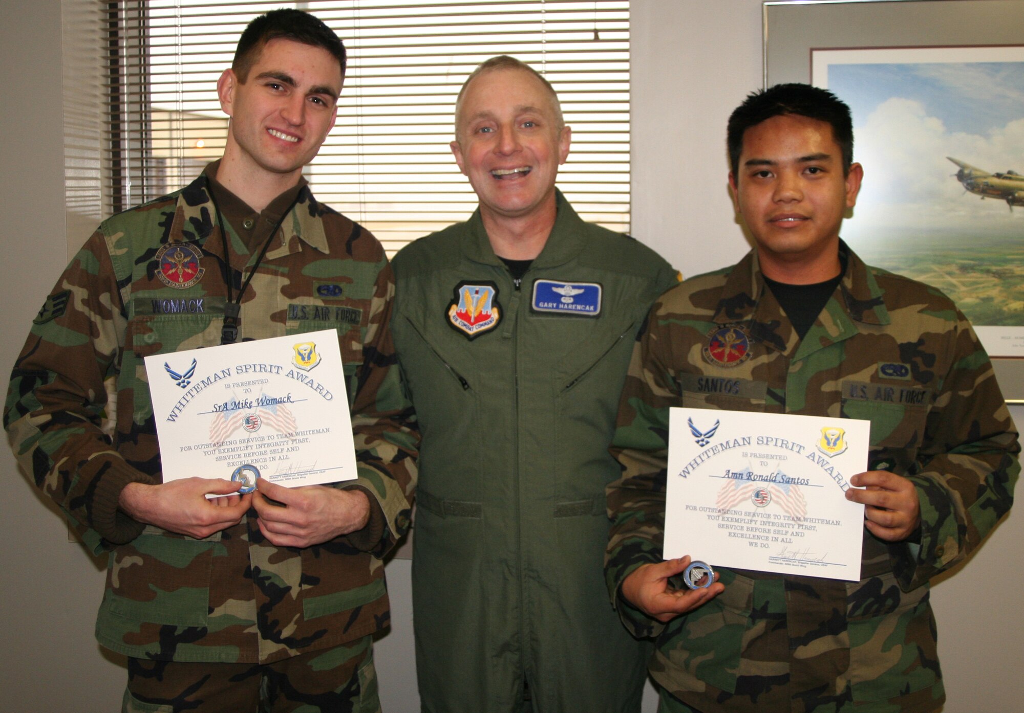 WHITEMAN AIR FORCE BASE, Mo. - Senior Airman Mike Womack and Airman Ronald Santos, 509th Maintenance Squadron, receive the Whiteman Spirit Award from Brig. Gen. Garrett Harencak, 509th Bomb Wing commander, Feb. 14. (U.S. Air Force photo/ 1st Lt. Candace Cutrufo)