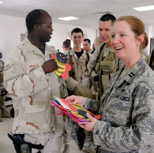 Capt. Meredith Ortiz hands out cards to members of the 379th Expeditionary Security Forces Squadron Feb. 13 at a Southwest Asia air base. Students from Merkel, Tye and Trent elementary schools mailed more than 300 Valentines to the base, thanking Airmen and coalition forces for their service and asking, "Will you be my Valentine?" Captain Ortiz is deployed from the U.S. Air Force Academy in Colorado Springs, Colo. (U.S. Air Force photo/Senior Airman Domonique Simmons) 
