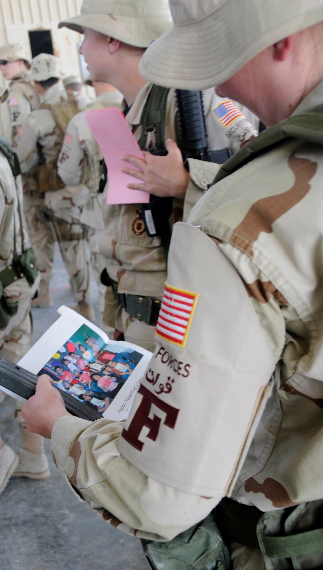 A 379th Expeditionary Security Forces Squadron member reads a Valentine from Merkel Elementary School students during a surprise "Be My Valentine" event Feb. 13 at a Southwest Asia air base. Students from Merkel, Ty and Trent elementary schools mailed more than 300 Valentines cards to the 379th Air Expeditionary Wing in support and appreciation of deployed servicemembers. Cards were distributed to Airmen deployed to the base as well as to wounded warriors at the base medical clinic. (U.S. Air Force photo/Senior Airman Domonique Simmons) 

